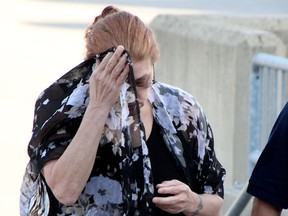 Karen Ebel-Savage covers her face as she approaches the Sarnia courthouse Thursday. The Sarnia woman was sentenced to three years in penitentiary for criminal negligence causing death. (Tyler Kula/Sarnia Observer)