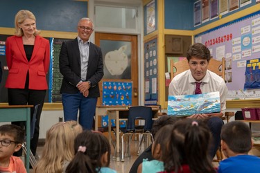 London West Liberal incumbent Kate Young, and London-Fanshawe Liberal candidate Mohamed Hammoud watch on as Prime Minister Justin Trudeau reads to pupils at Blessed Sacrament Catholic elementary school. (MAX MARTIN, The London Free Press)