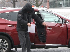 Claude Eric Trachy, seen in this file photo, kept his face hidden from view when arriving at the Chatham Court House in Chatham, Ont. for his trial in April 2018. (File)