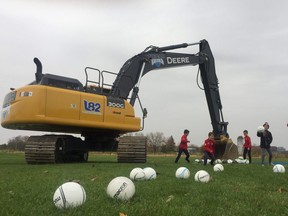 Players from TFC Academy in London kick balls dropped by an excavator at the future site of Tricar Field on Colonel Talbot Road on Wednesday. (Dale Carruthers / The London Free Press)