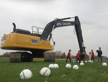 Players from TFC Academy in London kick balls dropped by an excavator at the future site of Tricar Field on Colonel Talbot Road on Wednesday. (Dale Carruthers / The London Free Press)