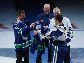 Former Vancouver Canucks captain Henrik Sedin presents a jersey to new captain Bo Horvat during a ceremony prior to facing the Los Angeles Kings at Rogers Arena on October 9, 2019 in Vancouver. (Photo by Ben Nelms/Getty Images)