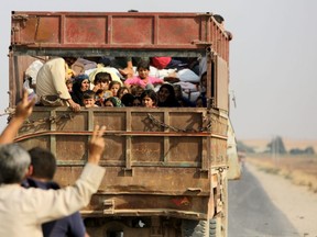 Kurdish Syrian civilians flee the town of Kobane on the Turkish border on Wednesday as Turkey and its allies continue their assault on Kurdish-held border towns in northeastern Syria. (Bakr Alkasem/AFP via Getty Images)