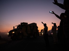 People wave as Turkish soldiers prepare to cross the border into Syria on October 09, 2019 in Akcakale, Turkey. The military action is part of a campaign to extend Turkish control of more of northern Syria, a large swath of which is currently held by Syrian Kurds, whom Turkey regards as a threat. U.S. President Donald Trump granted tacit American approval to this campaign, withdrawing his country's troops from several Syrian outposts near the Turkish border. (Photo by Burak Kara/Getty Images)