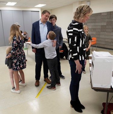 Conservative leader Andrew Scheer gets a hug from his son Henry as he talks with Thomas while standing with Grace, Mary and Maddie as Jill Scheer votes at a polling station in his riding in Regina, Saskatchewan, Canada October 21, 2019. Picture taken October 21, 2019. Adrian Wyld/Pool via REUTERS ORG XMIT: TOR505