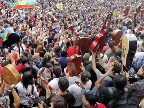 Musicians raise their guitars during a protest outside the National Library in Santiago, Chile October 25, 2019 in this still image taken from a social media video obtained October 31, 2019. (Carla Motto via REUTERS)