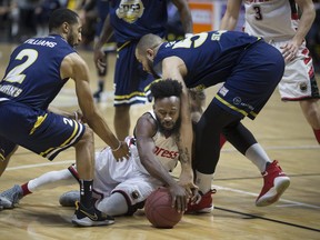 Windsor's Omar Strong hits the floor in a lose ball battle with St. John's Coron Williams, left, and Grandy Glaze in NBL of Canada action between the Windsor Express and the St. John's Edge at the WFCU Centre, Monday, February 19, 2018.  (DAX MELMER/Windsor Star)