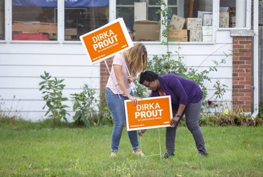 New Democrat candidate Dirka Prout, right, minds the election ground war, staking signs for her London-North-Centre campaign on Florence Street with help from volunteer Carla Joubert. (Derek Ruttan/The London Free Press)