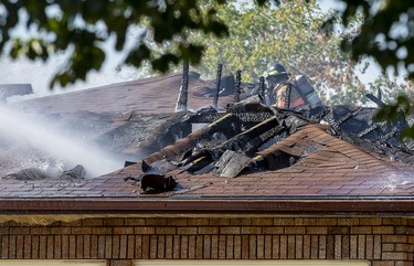 Firefighters work on dowsing a fire at 30 Parkside Cres. in London, Ont. on Monday September 30, 2019. A witness said the house was set ablaze by a barbecue. Derek Ruttan/The London Free Press/Postmedia Network