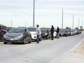 Oneida residents speak to drivers entering the community on Littlewood Road at Bodkin Road, one of several  checkpoints set up in response to an online threat. (Derek Ruttan/The London Free Press)