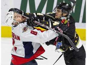 London Knight forward  Jonathan Gruden gets away with a check to the chops of defenceman  Connor Corcoran of the  Windsor Spitfires  in the first period of their game in London on Friday. (Derek Ruttan/The London Free Press
