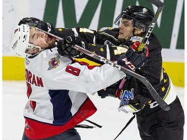 London Knight  Jonathan Gruden gets away with a cross check to the chops of Connor Corcoran of the  Windsor Spitfires  in the first period of their game in London on Friday. (Derek Ruttan/The London Free Press)