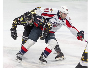 London Knights Alec Regula gets tied up with Luke Book of the  Windsor Spitfires in the first period of their game in London on Friday. (Derek Ruttan/The London Free Press)