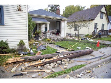 A splintered utility pole and a car bumper are among the debris littering the yard after a car -- which already tore a hole in the Society Cafe at the corner of Blackfriars Street and Wilson Avenue -- slammed into the house at 45 Blackfriars St. in London, Ont. on Sunday Oct. 27, 2019. (Derek Ruttan/The London Free Press)
