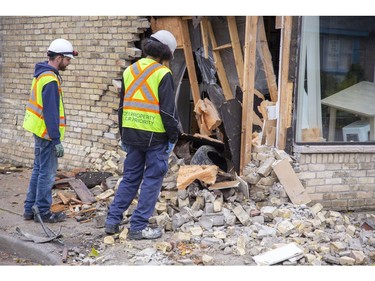 Restoration workers assess the damage after a car tore open a wall of the Society Cafe at the corner  Blackfriars Street and Wilson Avenue before crashing into a house at 45 Blackfriars St. in London, Ont. on Sunday Oct. 27, 2019. (Derek Ruttan/The London Free Press)