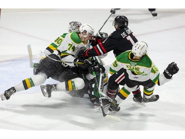 Jonah De Simone of the Niagara Ice Dogs takes out three London Knights players ( Brett Brochu, left, Ben Roger and Gerard Keane) with one check  during the first period of their OHL hockey game at Budweiser Gardens on Sunday Oct. 27, 2019. Derek Ruttan/The London Free Press