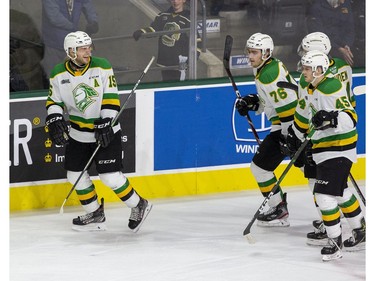 London Knight Cole Tymkin grins at teammates Billy Moskal, left, Jonathan Gruden and Gerard Keane after scoring during their OHL hockey game at Budweiser Gardens on Sunday Oct. 27, 2019. Derek Ruttan/The London Free Press