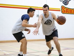 London Basketball Academy student Ryan Helm, right, breaks past David Ramirez as the two play a little one-on-one at Saunders secondary school in London. (Derek Ruttan/The London Free Press)