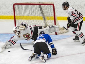 Sarnia Legionnaires goalie Jake Knowles lunges for a loose puck after making a save on London Nationals forward Ryan Martin during a Jr. ‘B’ hockey game Thursday at Sarnia Arena. The first place Nats won 6-5 in overtime. (Photo by Shawna Lavoie)