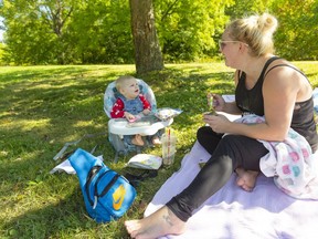 Danielle Huard, makes her daughter Vivan laugh as they have some lunch in the shade in Greenway Park.  Huard, was enjoying the sun on a day that warmed up a lot with even warmer temperatures expected for Tuesday. (Mike Hensen/The London Free Press)