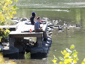 Christopher Stuifbergen fishes while Emily Cichocki uses binoculars to look at birds at the Forks of The Thames River  in London, Ont. on Wednesday October 9, 2019. Derek Ruttan/The London Free Press/Postmedia Network
