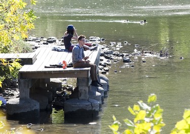 Christopher Stuifbergen fishes while Emily Cichocki uses binoculars to look at birds at the Forks of The Thames River  in London, Ont. on Wednesday October 9, 2019. Derek Ruttan/The London Free Press/Postmedia Network