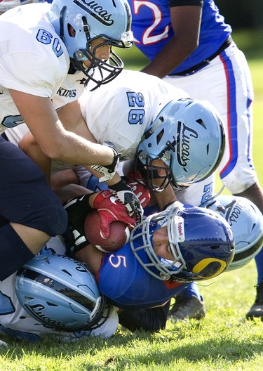 Oakridge Oaks ball carrier Mony Madlol is brought down by four Lucas Vikings including Kareem Abu Rafea (60) and Thomas Ashton (26) during their game at Lucas in London, Ont. on Thursday Oct. 10, 2019. The home team won the game 48-6. Derek Ruttan/The London Free Press