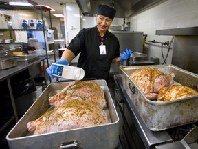 A lot of turkeys are being cooked this week at the Centre of Hope as the Salvation Army gets ready to feed between 300-350 people a Thanksgiving Day meal at their Bathurst Street location in London, Ont.  Iryna Galypchak sprinkles seasoning on four of the 12 x 20 lb. birds that are being cooked, about 275lbs of turkey in total. Mike Hensen/The London Free Press