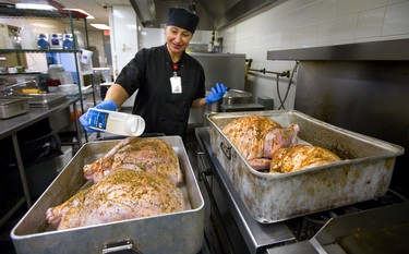 A lot of turkeys are being cooked this week at the Centre of Hope as the Salvation Army gets ready to feed between 300-350 people a Thanksgiving Day meal at their Bathurst Street location in London, Ont.  Iryna Galypchak sprinkles seasoning on four of the 12 x 20 lb. birds that are being cooked, about 275lbs of turkey in total. Mike Hensen/The London Free Press