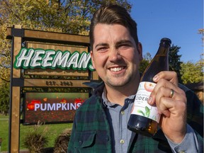 Tom Heeman, of Heeman's Garden Centre and Strawberry Farm, holds up a bottle of hard cider the family business has brewed for sale at its Nissouri Road east of London.  (Mike Hensen/The London Free Press)