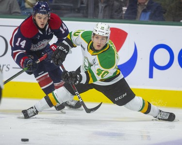 Antonio Stranges of the Knights passes back to the point as he loses his skates as he's checked by DJ Busdeker of the Saginaw Spirit during the first period of their game Friday night at Budweiser Gardens in London, Ont.  Photograph taken on Friday October 25, 2019.  Mike Hensen/The London Free Press/Postmedia Network