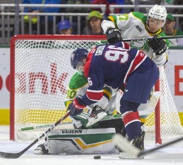 Matvey Guskov of the Knights is pushed back into his goaltender Brett Bochu by Damien Giroux of the Saginaw Spirit during the first period of their game Friday night at Budweiser Gardens in London, Ont.  Photograph taken on Friday October 25, 2019.  Mike Hensen/The London Free Press/Postmedia Network