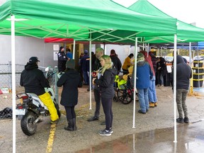 The city's week-long drive to help homeless people created a small lineup sheltered by tents outside Silverwoods Arena in London on Wednesday. (Mike Hensen/The London Free Press)