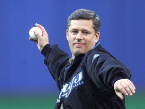 Stephen Harper throws out the first pitch at a Toronto Blue Jays-Tampa Bay Rays game while campaigning for prime minister. Photo taken in Toronto on June 22, 2004. (Craig Robertson/Postmedia files)