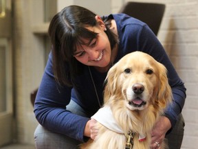 London fire Chief Lori Hamer bonds with therapy dog Mulligan, a five-year-old golden retriever, as 350 Southwestern Ontario public safety workers gathered to discuss on-the-job mental health issues at the Be Well Serve Well 2019 conference at London's Lamplighter Inn Wednesday. (DALE CARRUTHERS, The London Free Press)