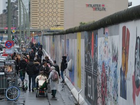 Visitors walk along a still-standing section of the former Berlin Wall called the East Side Gallery on November 6, 2019 in Berlin, Germany. November 9 will mark the 30th anniversary of the fall of the Wall that quickly led to the collapse of the communist East German government. Revolutions across other communist countries of the East Bloc soon followed. The Berlin Wall, built by the communist authorities of East Germany, stood from 1961 until 1989 and prevented people fleeing from East to West Berlin. At least 136 people, many of them shot dead by East German border guards, were killed trying to escape.  (Photo by Sean Gallup/Getty Images)