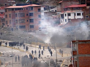 Bolivian Police officers clash with pro-Evo Morales demonstrators at South Area on November 11, 2019 in La Paz, Bolivia. Bolivian President Evo Morales resigned on Sunday afternoon after having called for fresh elections in the morning but losing support from some sectors of military and police forces. He accused the opposition of a coup d'etat. Audit from OAS on elections held on October 20 says that result cannot be verified after clear manipulations and should be annulled. (Photo by Javier Mamani/Getty Images)