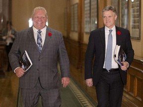 Ontario's Finance Minister Rod Phillips (right) is accompanied by Ontario Premier Doug Ford as he walks to the legislative chamber to deliver the fall Economic Statement on Nov. 6, 2019. (The Canadian Press)