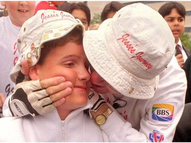 John Davidson shares a tender moment with son, Jesse, during the pair's 1995 trek across Ontario that raised $1.3 million for research into the disease that kills most victims in their late teens. (File photo)