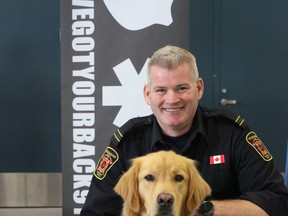 Mississauga Fire Department section  chief Ryan Coburn and service dog Ajax, a fully trained and accredited facility dog who helps members of the fire department address trauma and mental health challenges through "canine-assisted interventions." (MEGAN STACEY/The London Free Press)