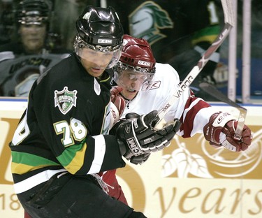 Knights Akim Aliu fights for the puck with the Guelph Storm’s Derek Brochu during the first period of Game 1 of their best-of-seven OHL Western Conference quarter-final last night at the John Labatt Centre. The Storm won 3-2 in overtime.