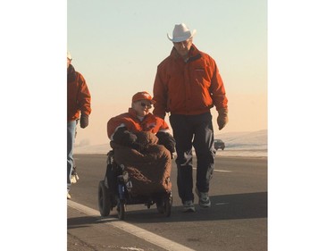 John Davidson is walking across Canada to raise money for genetic research, and arrived at Calgary's city limits on December 4, 1998. It marked his 240th day on the road and he just passed his 7000 km. Here he continues his walk with his son Jesse who has Duchenne Muscular Dystrophy. He continued after a short cheque presentation where he also received a white hat. The walk entitled Jesse's Journey-A Fathers Tribute  will continue after a five-day stay in Calgary.