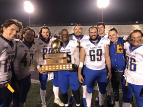 Saskatoon Hilltops team captains hold the Teddy Morris Memorial Trophy after beating the London Beefeaters 51-1 in the Canadian Junior Football League semifinal Saturday at TD Stadium in London. (Paul Vanderhoeven)