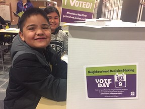 Antonio Camelo, front, and sister Abigail Elijah vote at the downtown London library on special projects proposed across across the city as part of city hall's Neighbourhood Decision Making program. (Heather Rivers/The London Free Press)