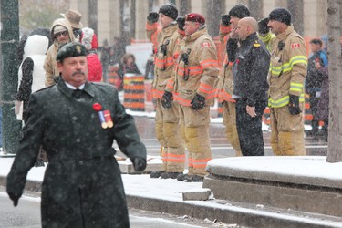 London firefighters salute the passing Remembrance Day Parade participants en route to Victoria Park on Monday, Nov. 11, 2019. (DALE CARRUTHERS, The London Free Press)