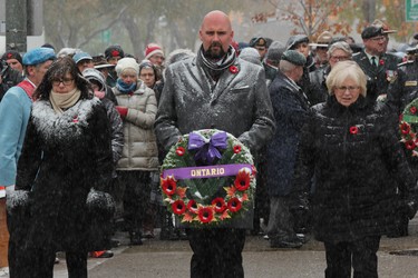 NDP MPPs Teresa Armstrong, left, Terrance Kernaghan, and Peggy Sattler carry a wreath to lay at the cenotaph in Victoria Park during the Remembrance Day ceremony on Monday, Nov. 11, 2019. (DALE CARRUTHERS, The London Free Press)