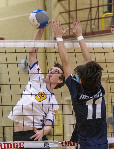 Oakridge's Shane Kloetstra hits the ball past CCH's Chris Di Marco during the WOSSAA  AAA junior volleyball final at Oakridge secondary school in London on Wednesday. Oakridge took the gold medal in three sets, 25-11, 25-7 and 25-13. (DEREK RUTTAN/The London Free Press)