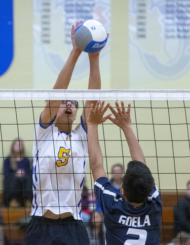 Oakridge's Stanley Rayevskiy hits the ball past CCH's Akshaye Goela during the WOSSAA AAA junior volleyball final at Oakridge secondary school in London on Wednesday. Oakridge took the gold medal in three sets, 25-11, 25-7 and 25-13. (DEREK RUTTAN/The London Free Press)