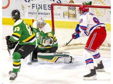 The puck nicks the glove of London Knight goalie Brett Brochu and flies wide of the net as Hunter Skinner and Kitchener Ranger Jonathan Yantis watch at the Kitchener Memorial Auditorium in Kitchener, Ont. on Friday Nov. 23, 2019. Derek Ruttan/The London Free Press