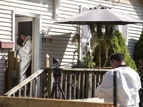 Members of the police forensics division collects evidence at 1070 Frances St. 7. Derek Ruttan/The London Free Press file photo